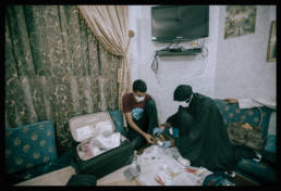 An injured man gets his wounds treated inside a home. Manama, Bahrain, 2013.